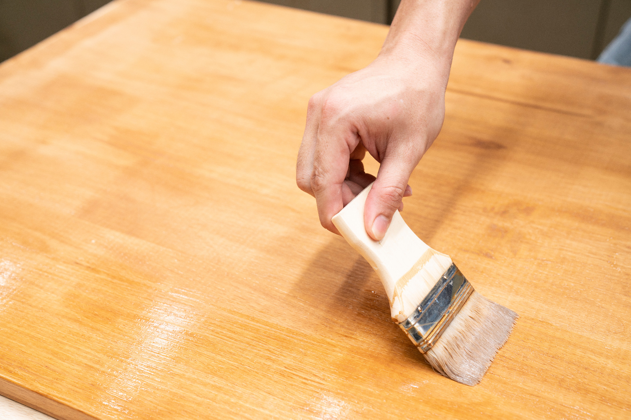 Wood Floor Sanding and finishing in Honor Oak, showing a hand brushing clear varnish onto a solid oak hardwood worktop surface similar to oak hardwood flooring.