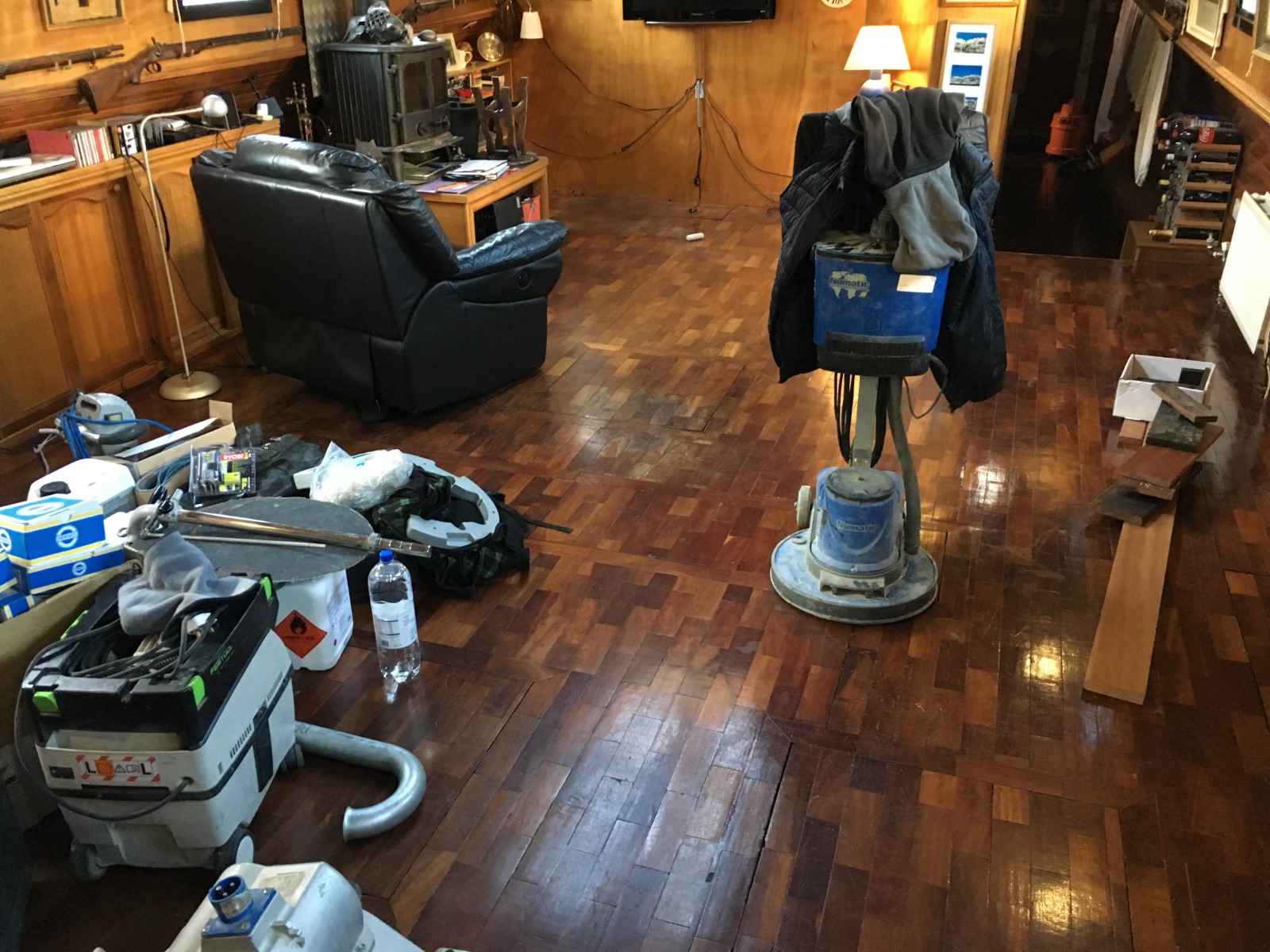 Commercial Floor Sanding in Honor Oak – dark hardwood parquet block floor in a commercial lounge being prepared with sanding machines and tools before restoration.